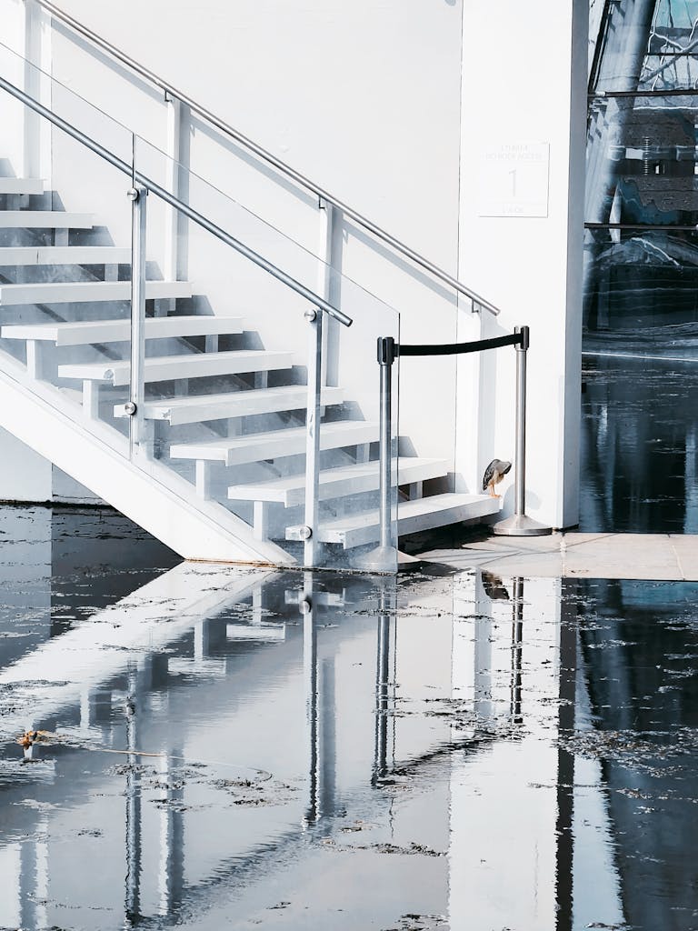 Flood Water on Concrete Floor and a White Concrete Staircase